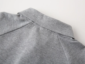 Détail du col d'un polo gris pour garçon montrant la texture du coton piqué premium