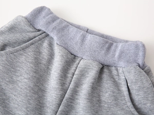 Close-up of elastic ribbed waistband and side pockets on heather grey cotton joggers