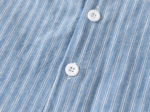 Detail of blue and white striped cotton shirt showing white buttons and fabric texture