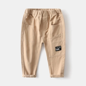 Detail of children khaki trousers featuring elastic waistband and stylish logo patch
