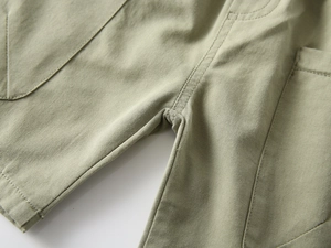 Macro shot of olive green cargo shorts featuring reinforced crotch stitching and large pockets