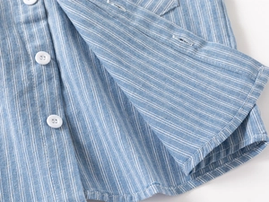 Close-up of blue and white striped shirt fabric with textured white buttons and neat stitching