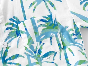 Close-up of tropical palm tree print on white cotton shirt with neat chest pocket detail