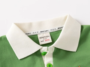 Détail du col d'un polo en coton piqué vert avec doublure blanche et bande logo tissée