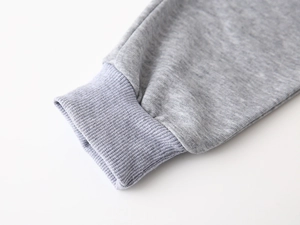 Close-up of grey knit sweatshirt sleeve with blue-grey ribbed cuff and fine stitching