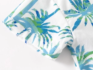 Detail of boys' short sleeve shirt showing tropical palm tree print and linen texture