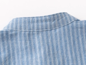 Detailed view of the simple stand-up collar and blue striped texture on the kid shirt