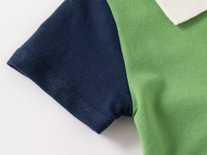 Gros plan du polo enfant en coton piqué avec détails de couture et manches contrastées
