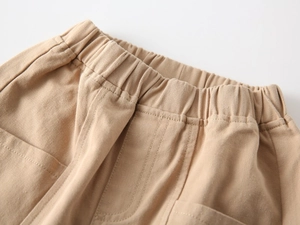 Detailed macro view of kids' khaki trousers featuring an elastic waistband and fine stitching
