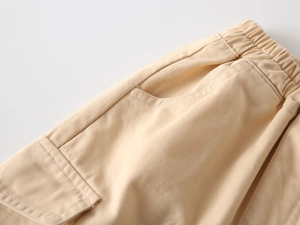 Detailed macro view of the elastic waistband and pocket stitching on cotton kids trousers