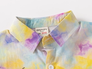 Detailed view of the collar and colorful tie-dye print on this boys short sleeve shirt