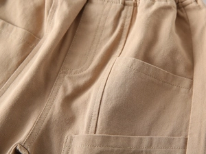 Detailed close-up of khaki cotton twill pants featuring elastic waist and reinforced stitching