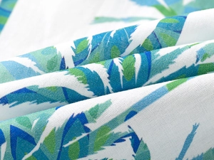 Close-up of tropical leaf print fabric showing breathable linen texture on boy's summer shirt
