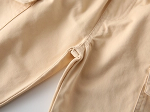 Macro detail of reinforced crotch stitching on kids khaki cotton twill trousers