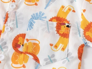 Detailed close-up of cute cartoon lion print and stitching on white cotton boy's shirt