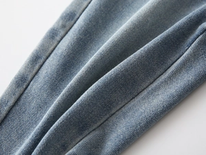 Macro view of light blue denim fabric texture showing cotton twill weave for boys jeans