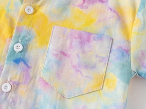 Macro view of colorful tie-dye patterns with white button and chest pocket details