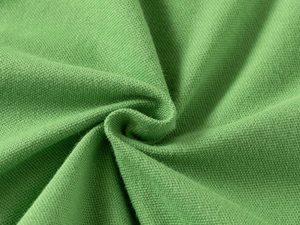 Macro de la texture du tissu en maille piquée vert herbe montrant le détail du coton