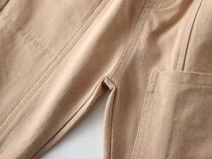 Detail shot of khaki twill cotton fabric showing high-quality stitching and seam on kid pants