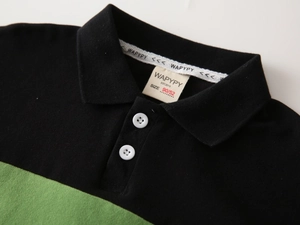 Detail of kids polo shirt collar with green contrast trim and white buttons
