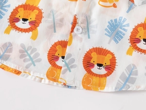 Detail of child shirt with yellow cartoon lion prints and white button closure