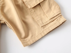 Dettaglio del tessuto in twill di cotone kaki con ampie tasche cargo e doppie cuciture rinforzate