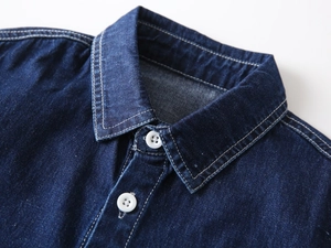 Detail of classic denim collar with white buttons and double stitching on kids shirt