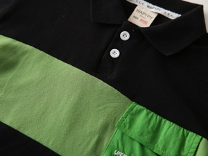 Detail of color-block boys' Polo shirt showing the green cargo pocket and piqué fabric