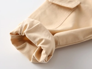 Detailed macro view of khaki cargo pants showing twill fabric texture and clean hem stitching