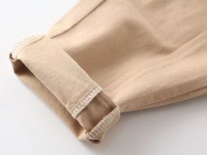 Macro detail of khaki cotton chino pants with folded cuff and durable white lockstitch seam