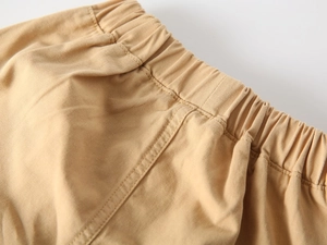 Dettaglio di pantaloncini in twill di cotone kaki con vita elastica e cuciture precise
