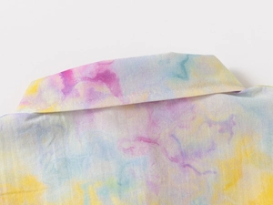 Close-up of the pastel tie-dye pattern and neckline stitching on a boy's casual shirt