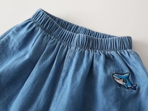 Close-up of kids light blue denim pants featuring elastic waist and shark embroidery
