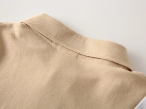 Macro detail of khaki polo shirt collar showing premium pique fabric texture and stitching