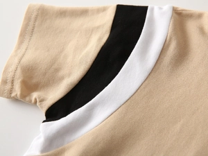 Macro view of color-blocked pique cotton fabric on boy's polo shirt shoulder