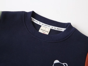 Detail of round neckline and contrast patchwork sleeves on warm fleece sweatshirt