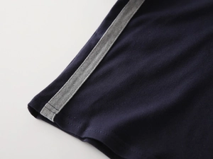 Macro detail of navy blue pique knit cotton fabric with gray contrast stitching