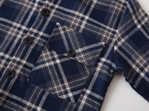 Detailed view of kids navy plaid flannel shirt with durable chest pocket and buttons