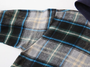 Gros plan sur la texture et les coutures du tissu en flanelle à carreaux bleus