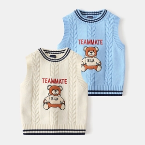 Detail of knitted kids vest featuring heavy bear embroidery and cable-knit texture