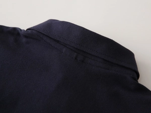 Detailed close-up of navy blue kids polo shirt collar with premium pique mesh texture