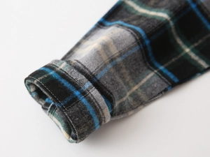 Gros plan sur les coutures et la texture du flanelle de cette chemise à carreaux