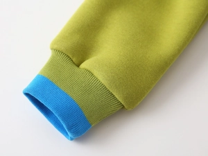 Vue détaillée du poignet côtelé vert sarcelle avec bordure contrastée bleue vive