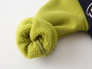 Gros plan du poignet de la veste avec doublure en polaire verte et coutures précises