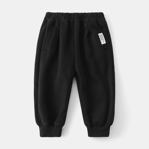 Dettaglio dei pantaloni sportivi neri per bambini con vita elastica ed etichetta tessuta