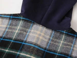 Détail d'une chemise à capuche à carreaux montrant la texture et les coutures soignées