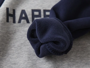 Detail of gray knit sweatshirt showing thick dark blue fleece lining and printed letters