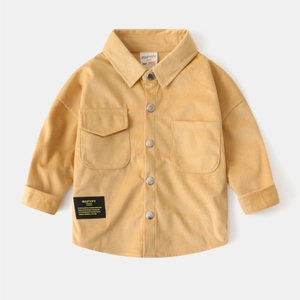 Macro detail of the yellow corduroy fabric and metal buttons on children long sleeve shirt