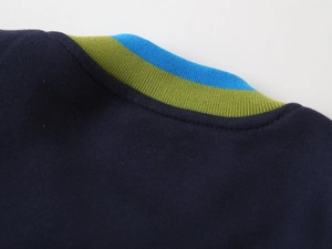 Détail de la veste enfant bleue avec col en maille rayé et finitions soignées