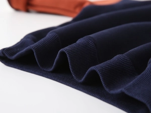 Detail of ribbed hem and durable stitching on children's fleece sweatshirt with color contrast
